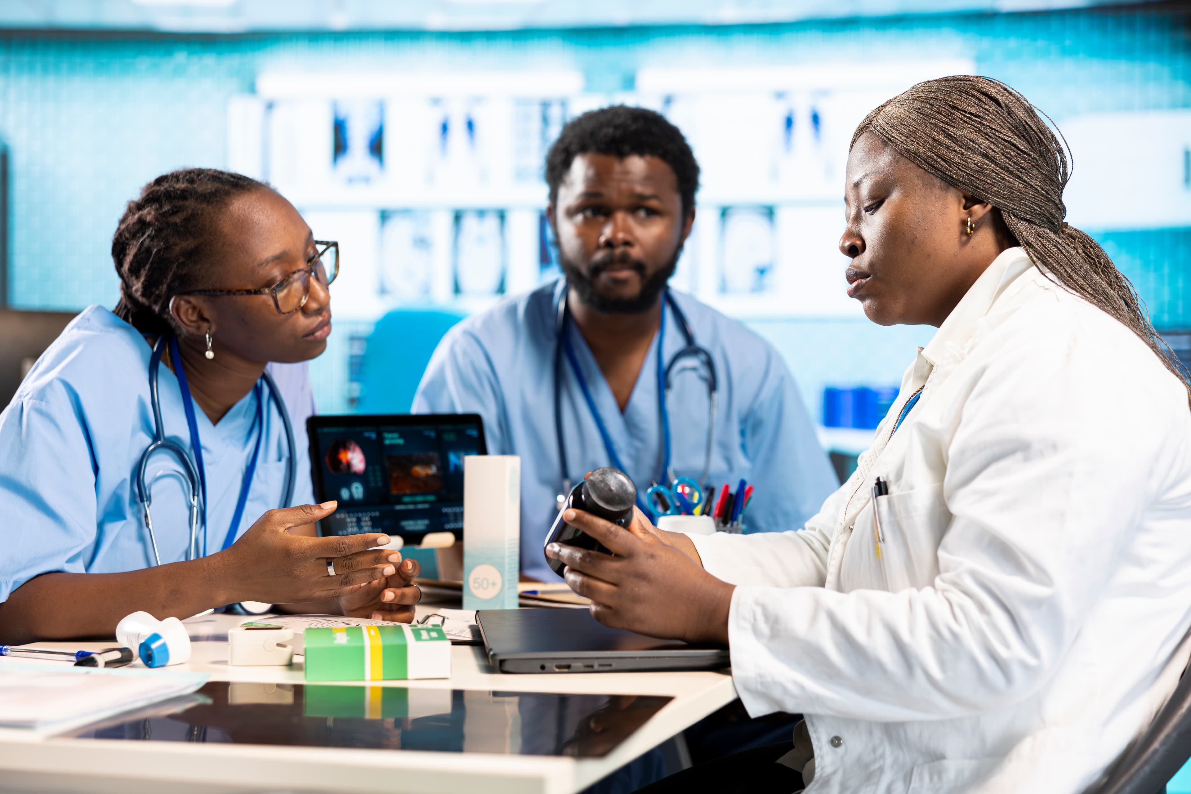Trois professionnels de santé échangent au sein d’une pharmacie